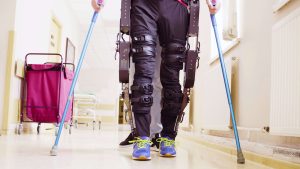 man walking with crutches and robotic exoskeleton on legs